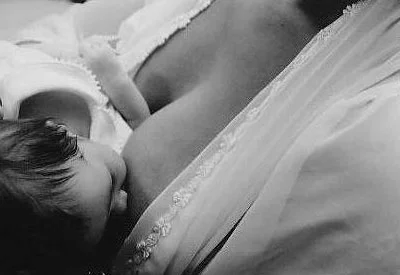 A parent breastfeeding their baby